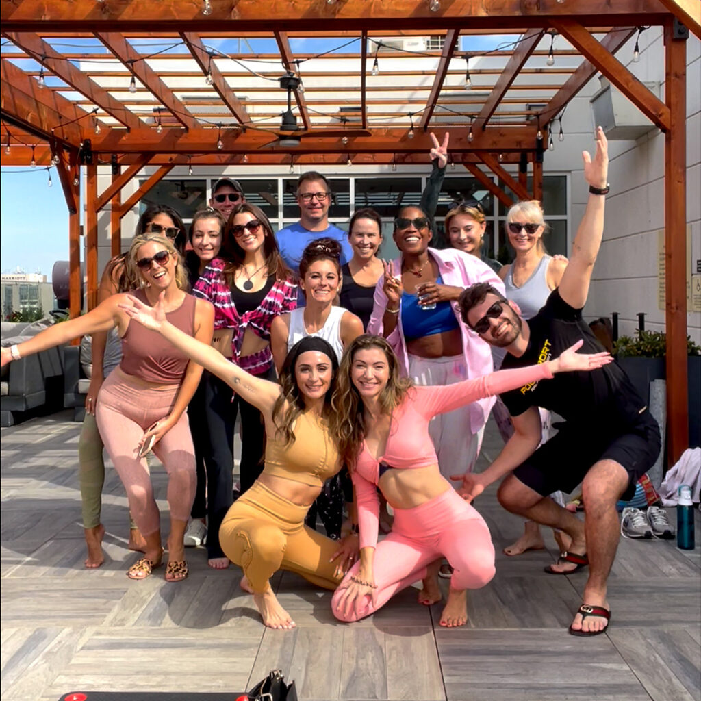 Group of people practicing yoga on a rooftop with Lost Art Yoga.